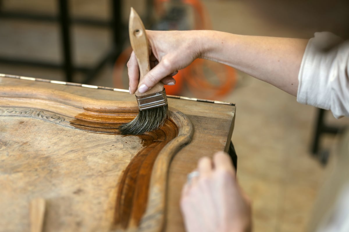 Restoring ornate wooden furniture detail by hand