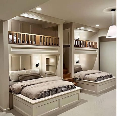 Modern bedroom with four built-in bunk beds with cream-colored wooden frames and integrated shelving in a minimalist design.